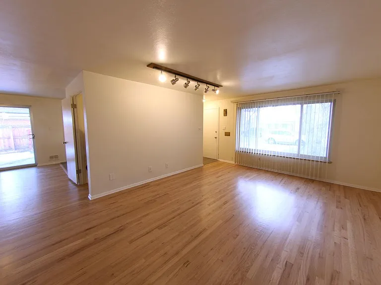 Spacious Upstairs Living area with large window looking out to front of home and mature landscaping.