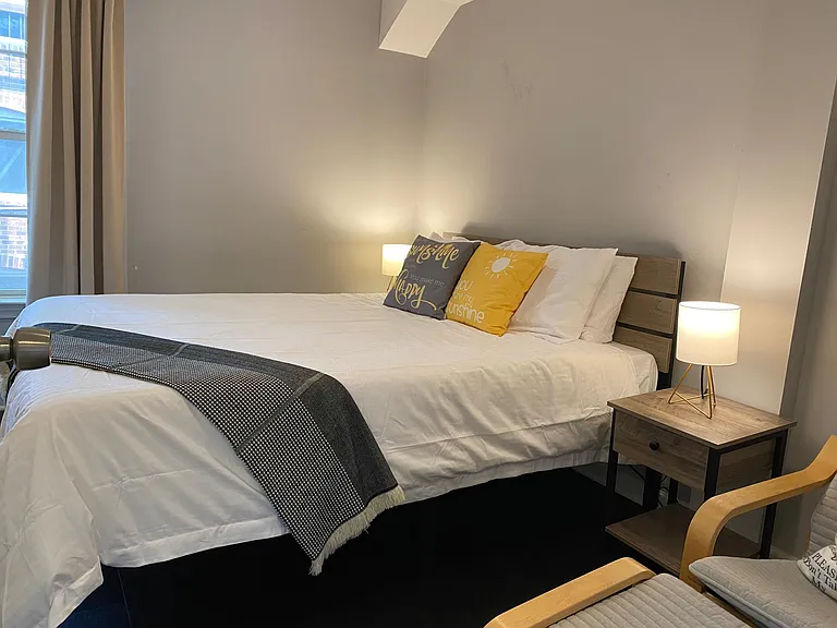 bedroom #1 on entry level features queen bed, desk, and lounge chair.