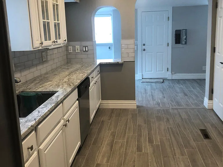 Kitchen looking N toward Sunroom. New granite counters, new glass backsplash, new tile floors.
