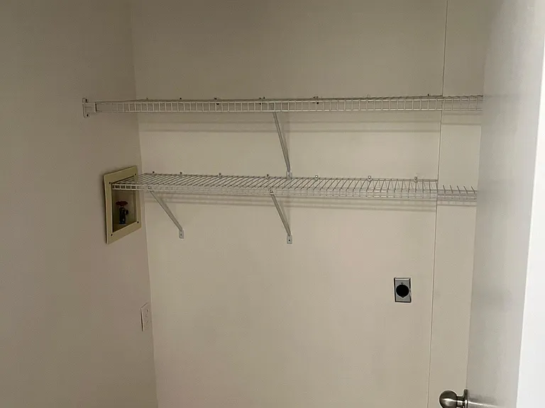 Laundry room with hook ups and shelving.