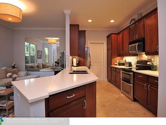Kitchen w/ quartz counters, SS appliances and cherry cabinets