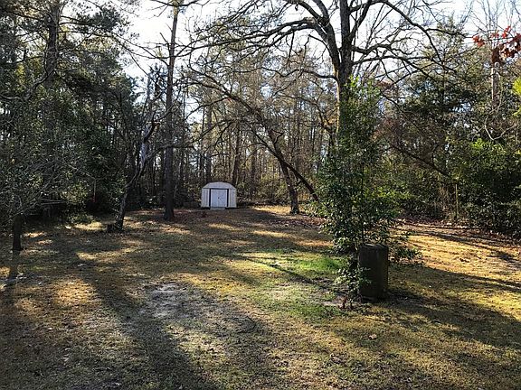 View of fenced in backyard with shed in the back