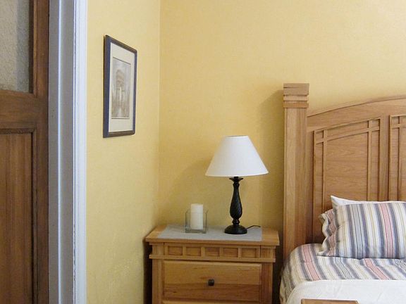 Master bedroom with a king-sized bed. Door on the left leads into the private bathroom.