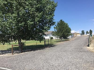 Driveway and entrance. Vacant field lot to south