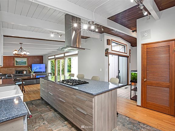 Open floor plan, chefs eat in kitchen, dining room and living room with gas fireplace at far end of photo