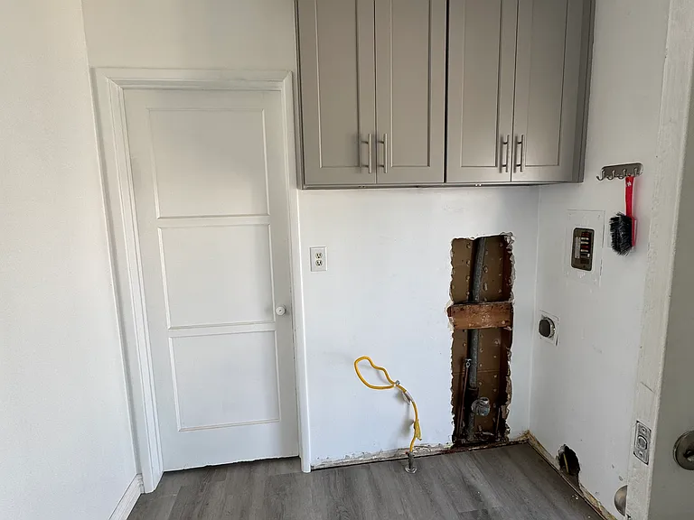 Washer and Dryer Hookups with extra cabinets in Service Porch