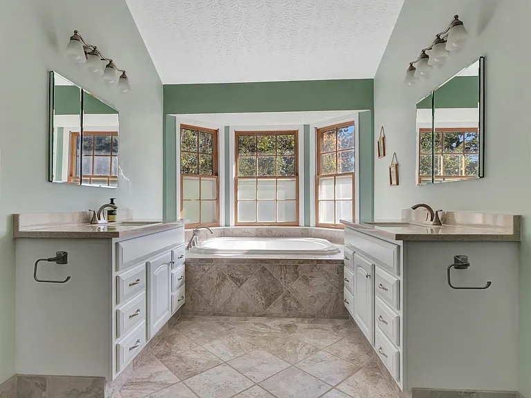 master bath with soaking tub and 2 sink areas