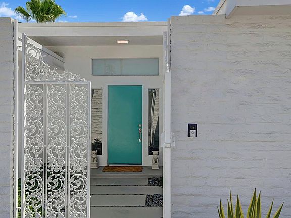 Front door entrance behind wrought iron gates .