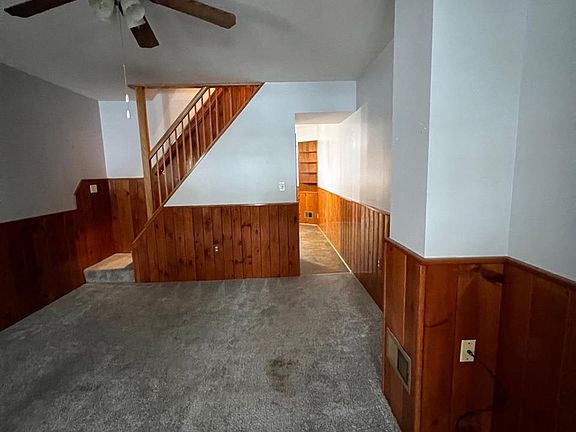 Living room view to dining room and staircase to second floor