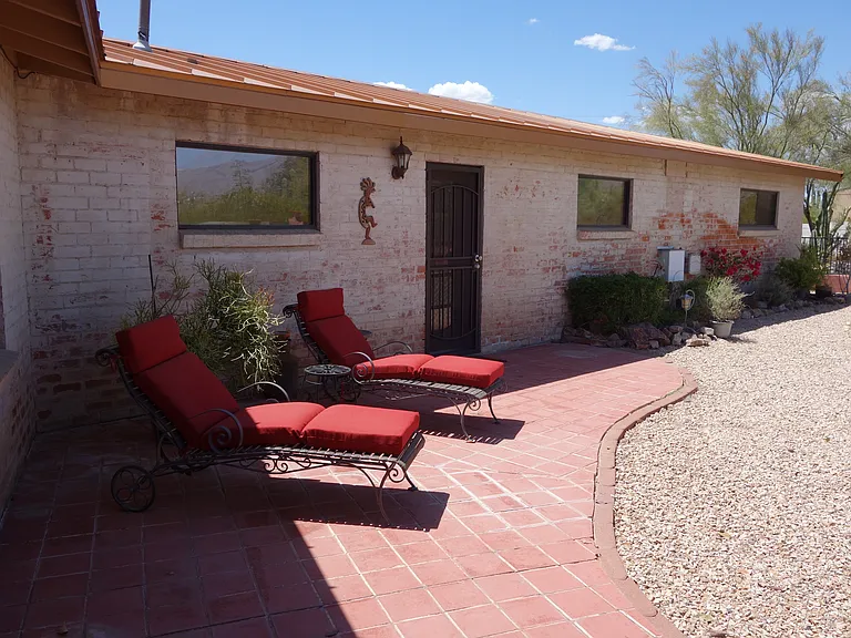 Fenced in back yard with patio. Lounge chairs as well as a bistro table.