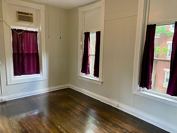 Large bedroom with lots of windows and AC unit.