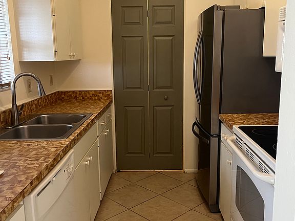 Galley kitchen and pantry doo. Pantry door includes stackable washer dryer