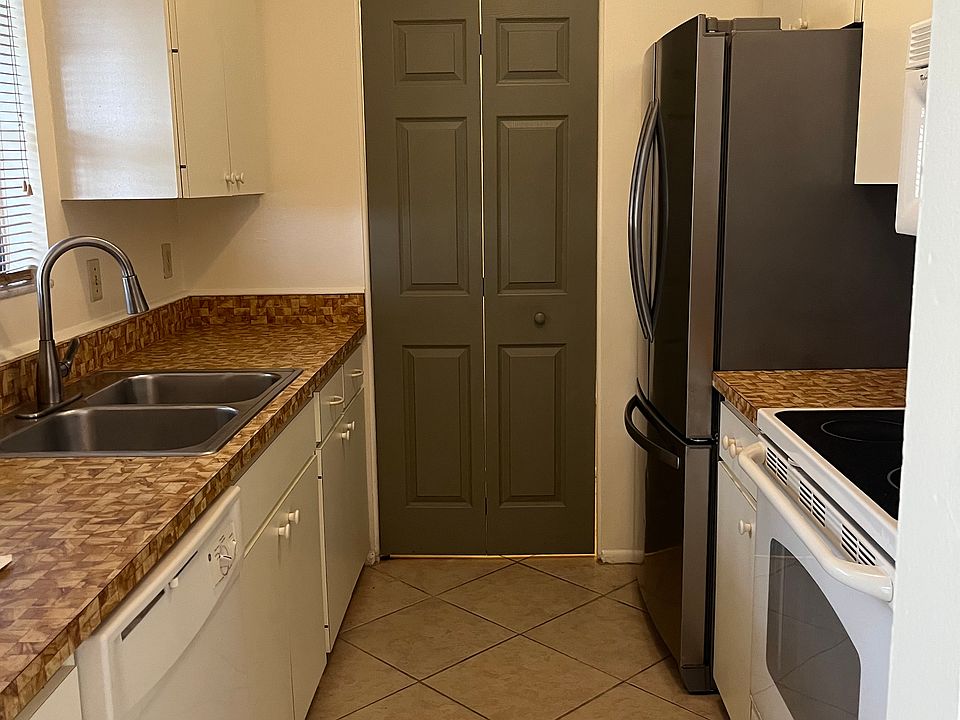 Galley kitchen and pantry doo. Pantry door includes stackable washer dryer