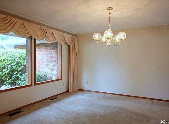 The dining room carries on the coved ceilings and wood wrapped windows.
