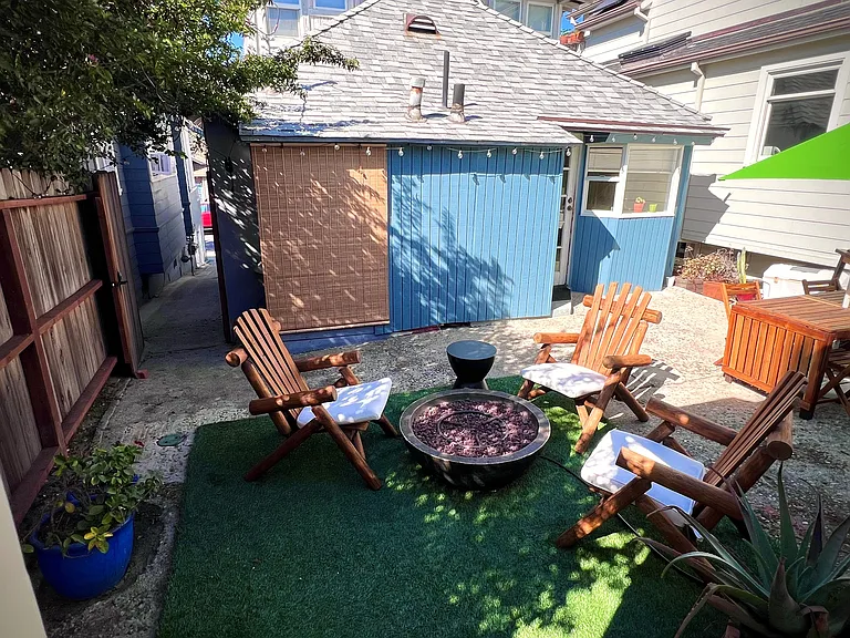 View of patio from front door looking out. Street entrance and secured gate on the left. Washer and Dryer located behind bamboo roll-up blinds on the front house just right of entrance.