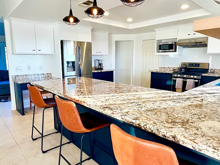 Additional views of the kitchen with a built-in desk and refrigerator/freezer. A separate door leads to a walk-in pantry