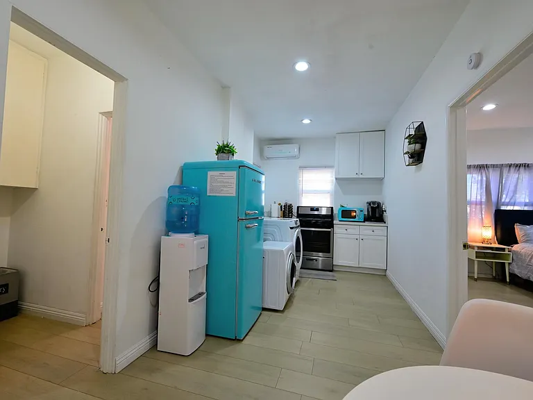 Fully furnished living room with upgraded kitchen, appliances, and laundry machines