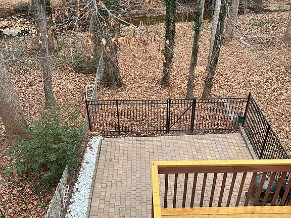 View out the window from top floor back yard bedroom shows creek and walking path behind creek that is Mine Creek Trail and Raleigh Greenway.
