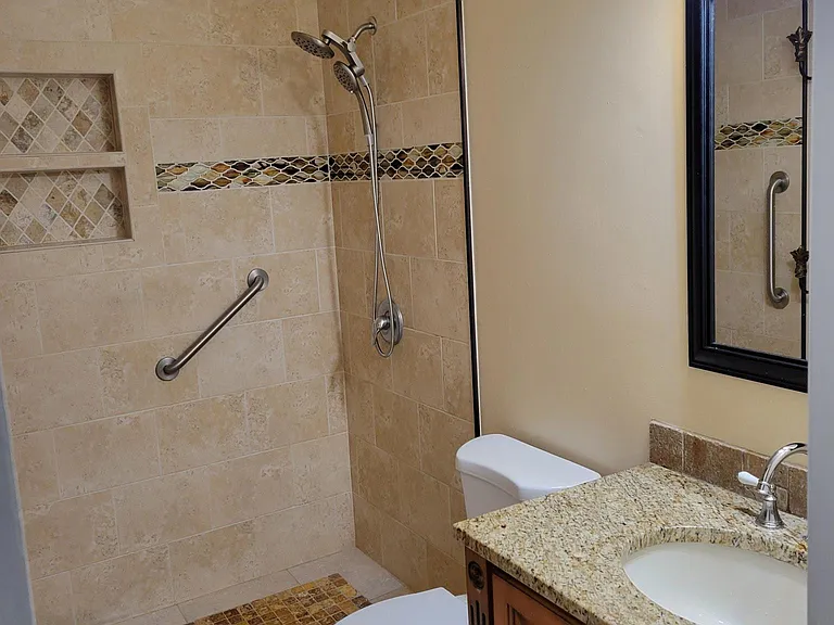 Walk in shower with new shower head and faucets.