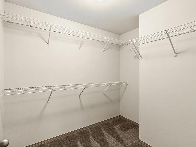 Large walk-in closet with ample built-in shelving for organized storage. Large walk-in closet with ample built-in shelving for organized storage.