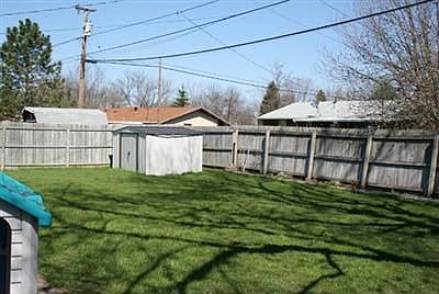 Backyard, with patio, privacy fence, and storage shed.