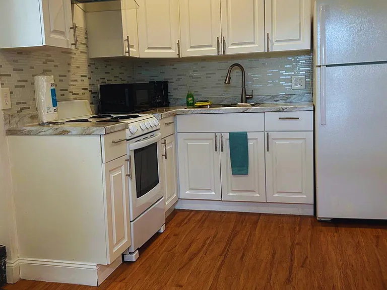 The kitchen is equipped with a refrigerator, coffee maker, and essential amenities.