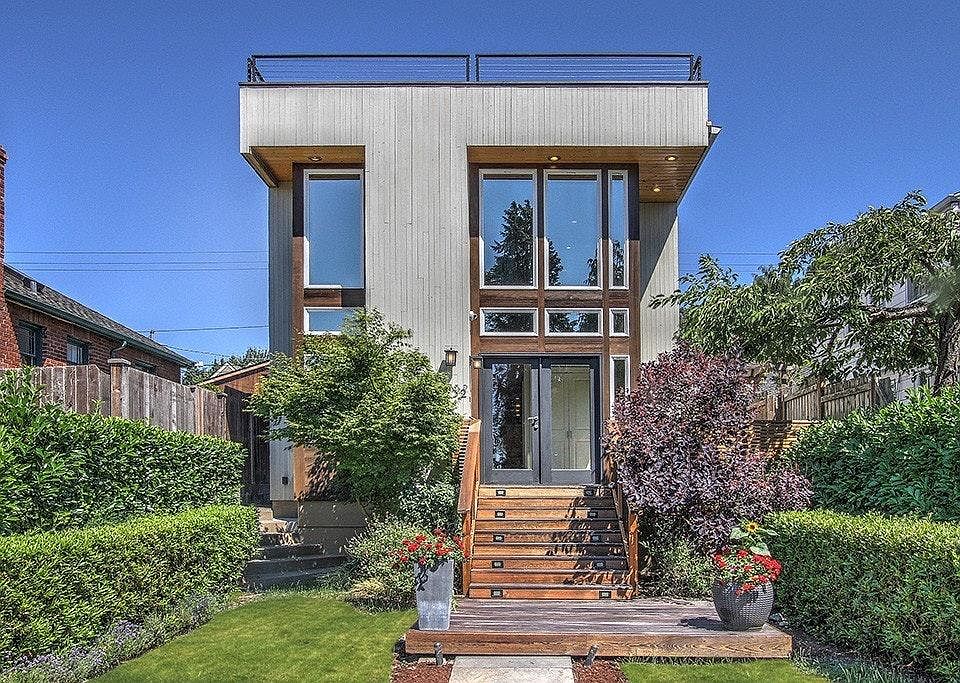 View of front of house. There is a deck that runs along the 