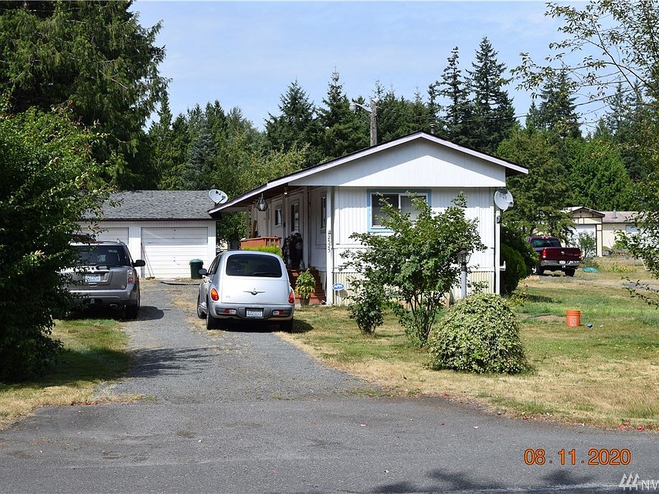 Street view with full shed style roof, detached 2 car garage and driveway parking