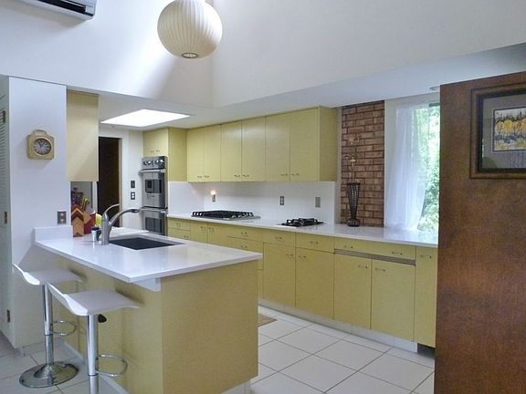Original cabinets with updated Viking and Bosch stainless appliances, tile floors, and vaulted ceilings in the bright kitchen!