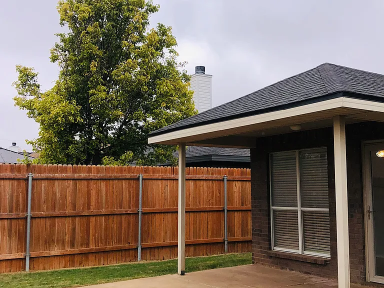 Covered porch and patio area. Large yard with new fence.