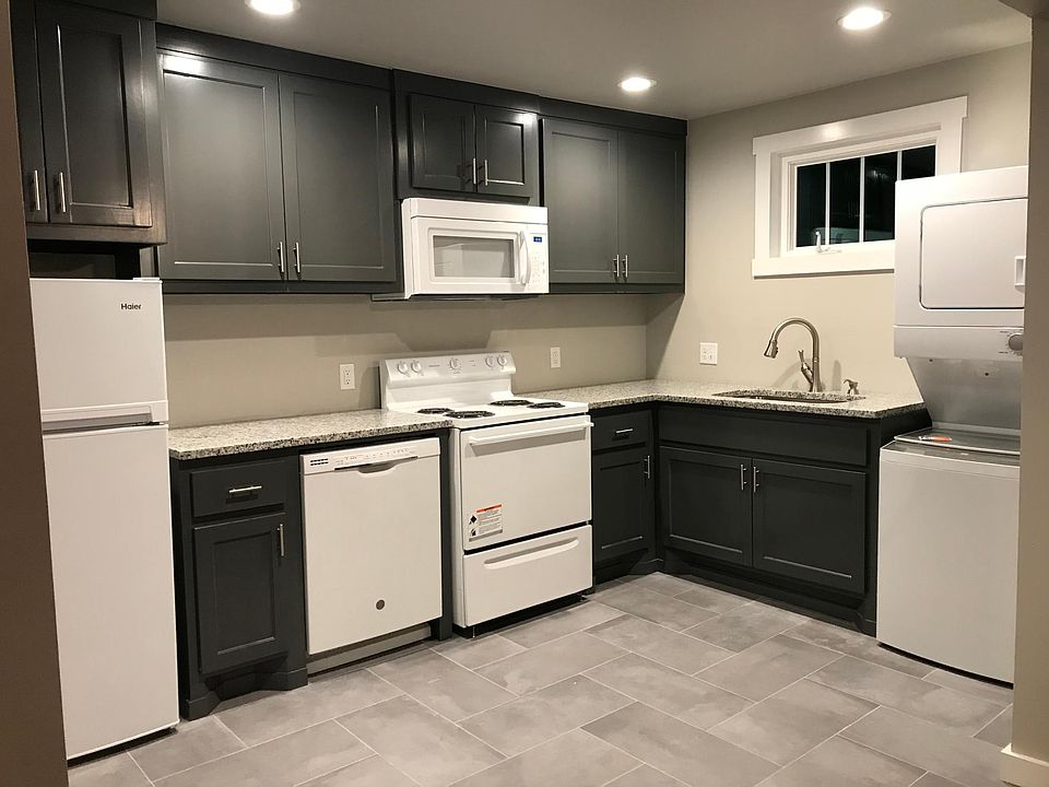Upstairs kitchen complete with all-new appliances, stack washer dryer, concrete look tile floors, granite counters, large steel 
