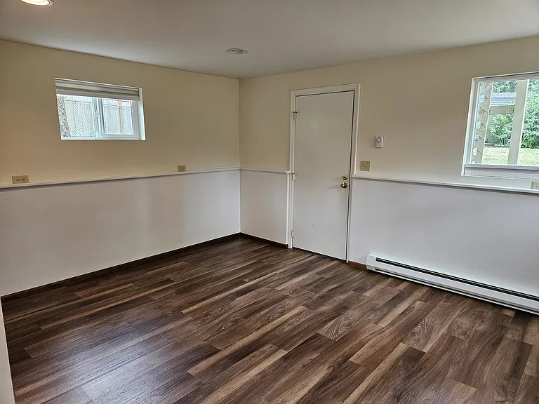 basement bedroom looking NE, showing exterior door to staircase to backyard.