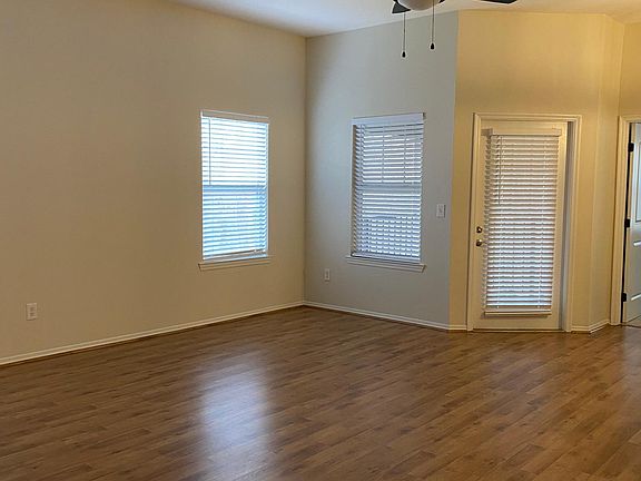 Spacious Living Room with New Ceiling Fan and Access to the Screened Lanai (Freshly Painted Throughout).