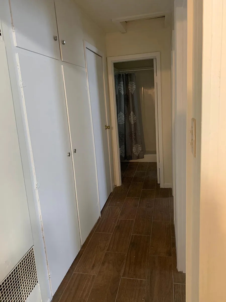 Hallway from front door to bedrooms and bathroom. Storage cabinets along the hallway. - 3408 E Red River St