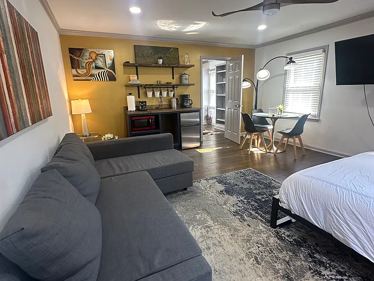 Downstairs bedroom comfort meets convenience _ sofa, TV, kitchenette, and perfect for any moment.