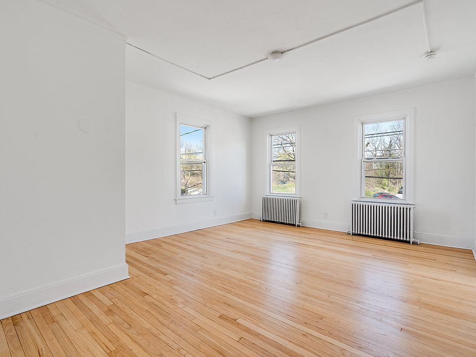 Large living room featuring arched walkways, and light hardwood flooring