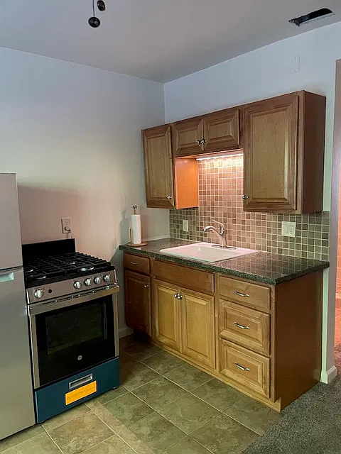 Kitchen wood cabinets and granite countertop with counter lighting