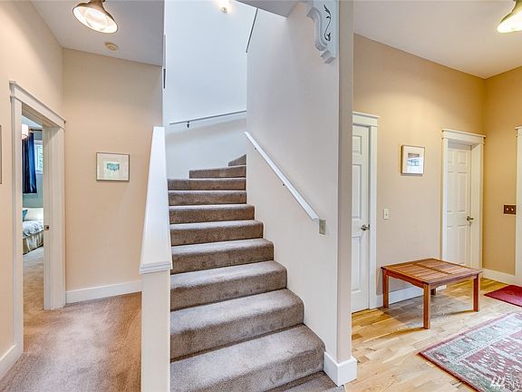 Off the entry.  Door to the far right is the utility room and powder room.  Door to the right of the stairs leads to the unfinished basement, to the left of the stairs is the main floor master suite.