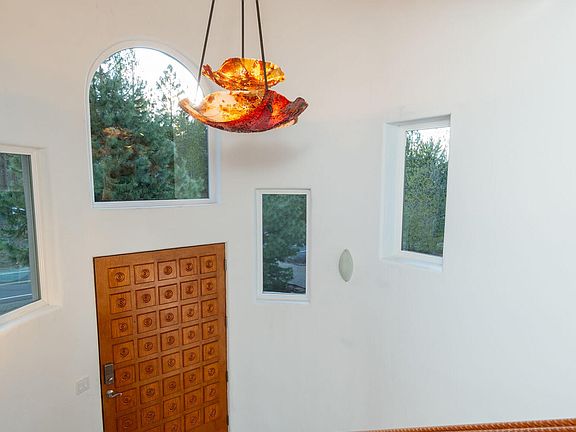 Grand entry with carved mountain scene in the beam, and hand blown light fixture>