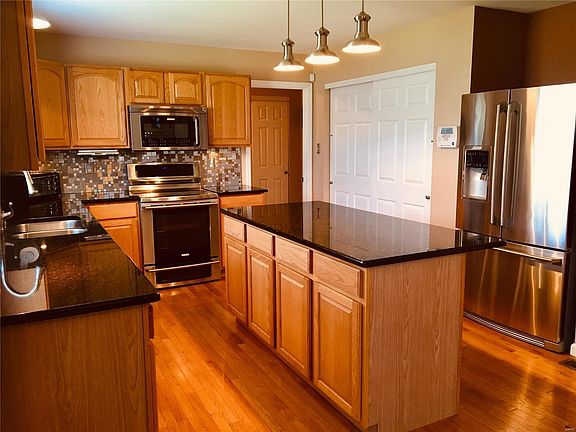 Updated kitchen with granite, stainless appliances and custom back splash.