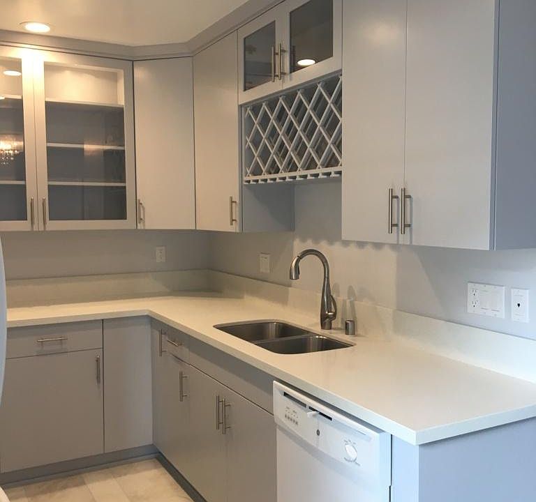 View of opposite side of the kitchen with a wine rack, brand new sink dishwasher, and storage with two lazy suzies.