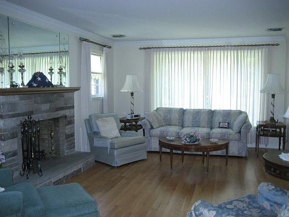 Entry Foyer opens to living room with stone fireplace and new hardwood floors.