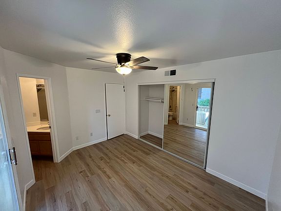 Primary bedroom with en suite, spacious closet, and sliding glass door to first floor patio