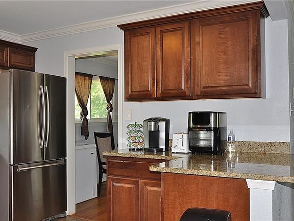 Kitchen with stainless steel appliances and granite counter tops leading into the dining room