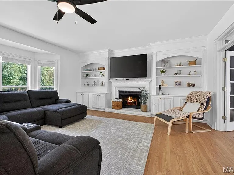 Spacious living area featuring light wood-finish flooring and a bay window