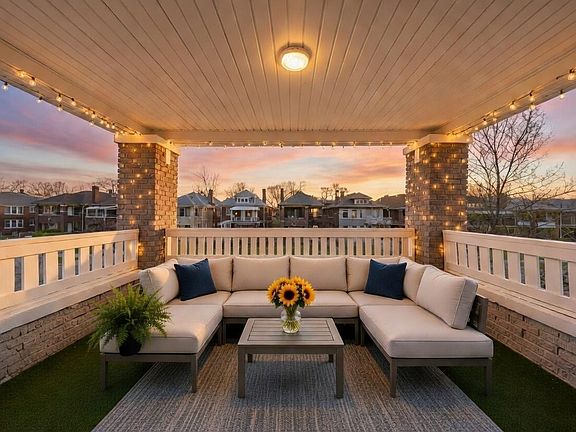Step out onto your spacious, covered balcony, offering a charming skyline view of this quiet Detroit neighborhood. Image is virtually staged