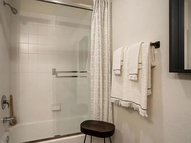 Shower and Tub with White Tile Surround and Sliding Glass Doors