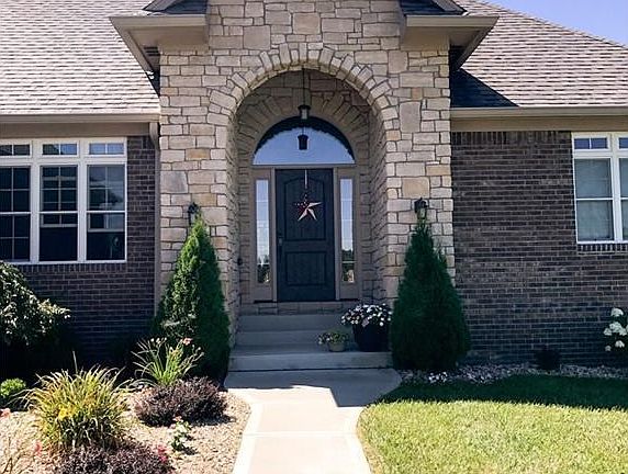 Arched stone entry way with Craftsman style door