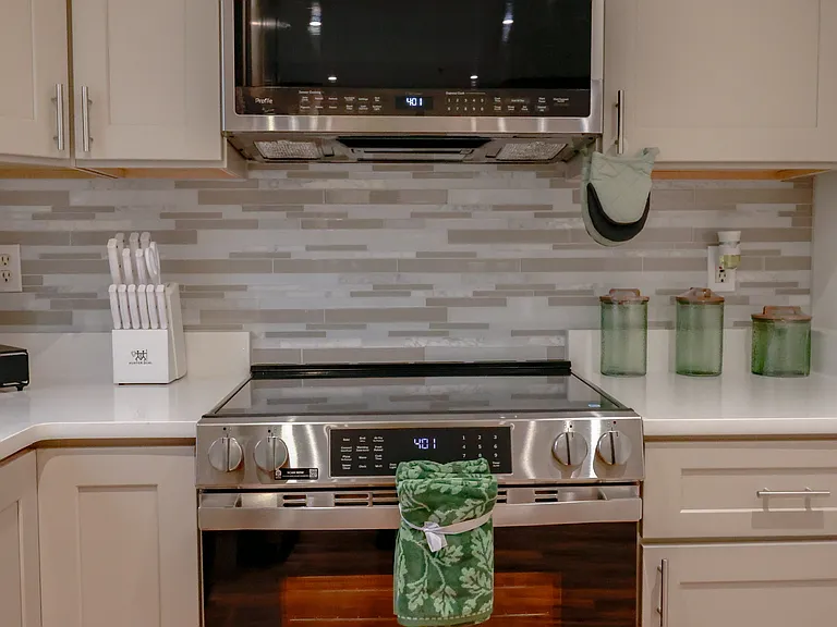 Fully updated kitchen with stainless steel appliances, modern tile backsplash, custom cabinetry, and sleek built-in microwave. Designed for both style and functionality.