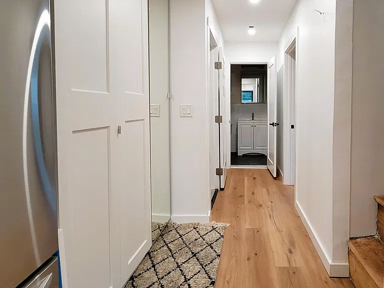 Hallway picture shows the main bathroom and the steps to the apartment's second level.